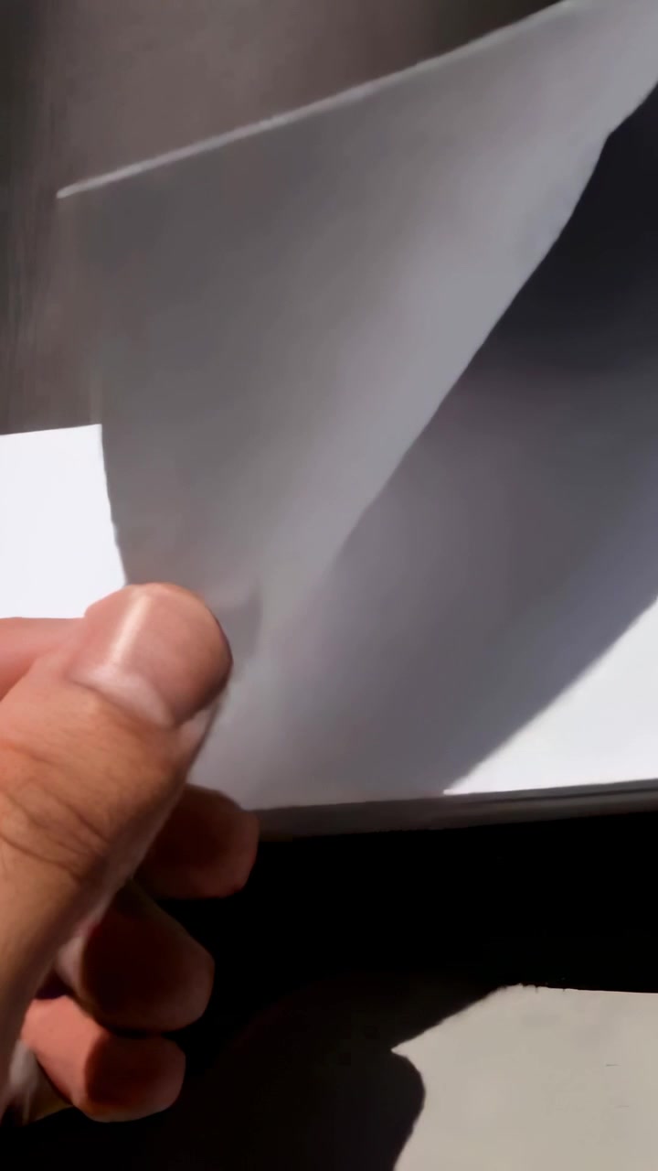 Vertical video: Entering hand peeling sheet corner to separate sheet from pad on table, copy space
