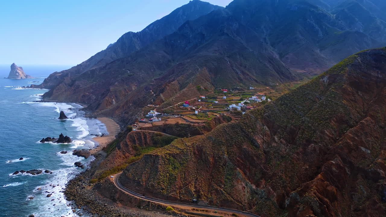 Highway along the mountain slope leading to the residential area. Drone footage at the shore of the Atlantic Ocean revealing view on Tenerife, the Canary Islands, Spain