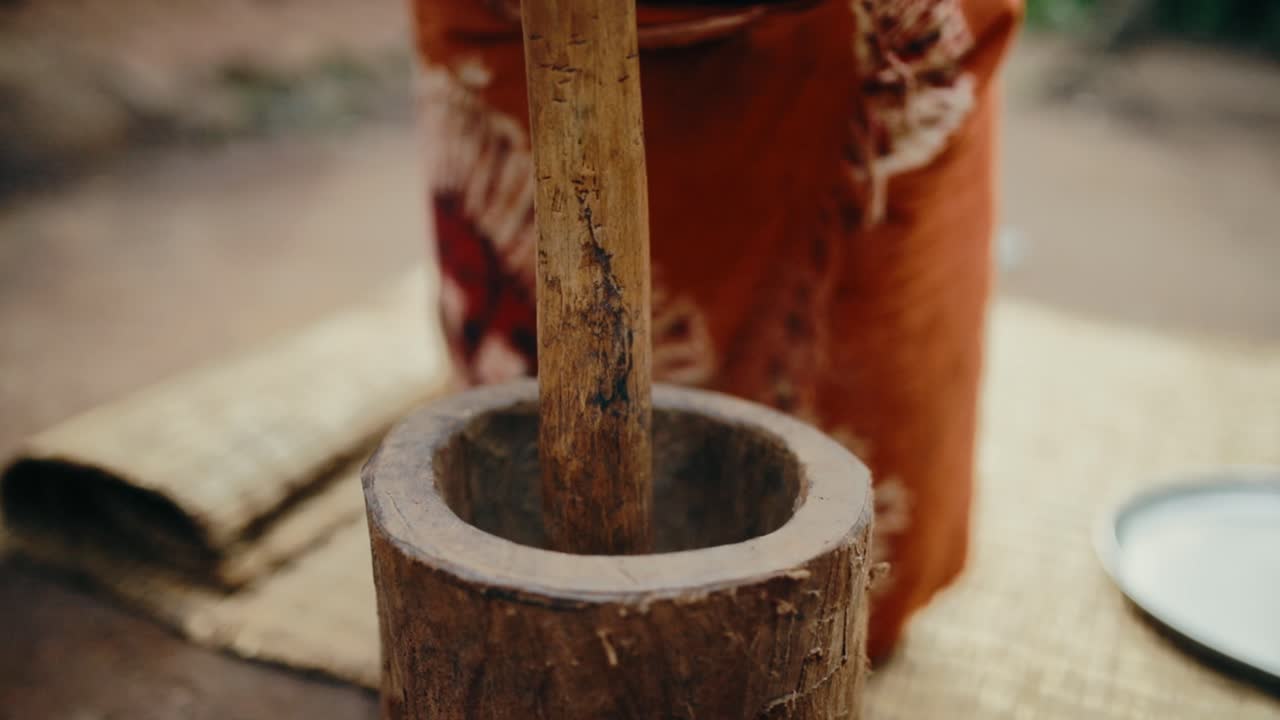 Traditional wooden mortar and pestle used to grind roasted coffee beans into ground coffee - traditional Ugandan coffee making process