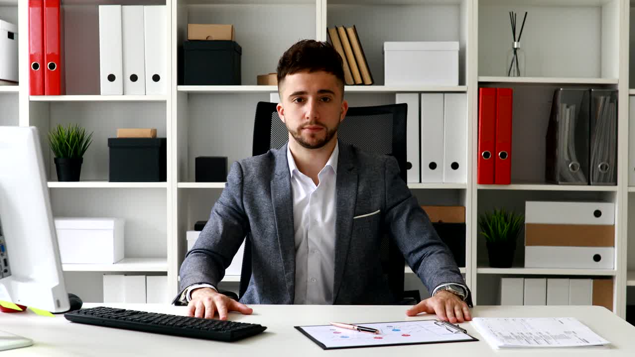 businessman in workplace shaking head and looking at camera