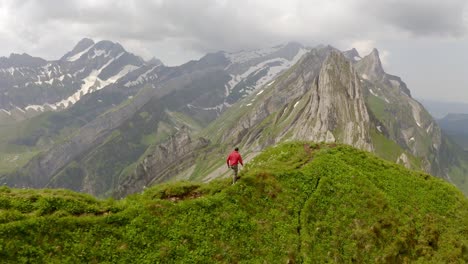 un hombre con una chaqueta roja camina sobre una montaña