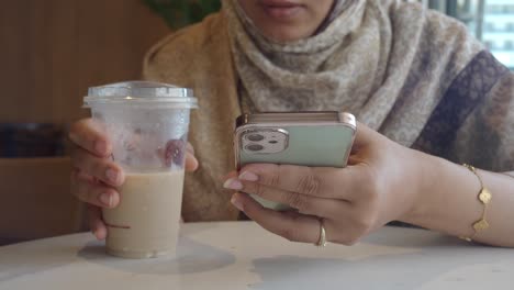 mujer usando el teléfono en un café