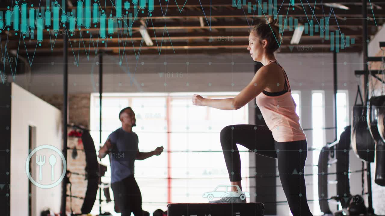 Woman timing box jumps to man swinging jump rope, teal data overlays tracking fitness metrics