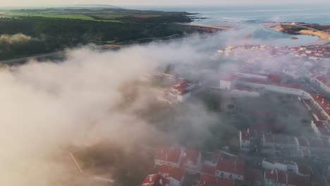 foggy clouds over coastal town of lisbon, portugal during sunrise