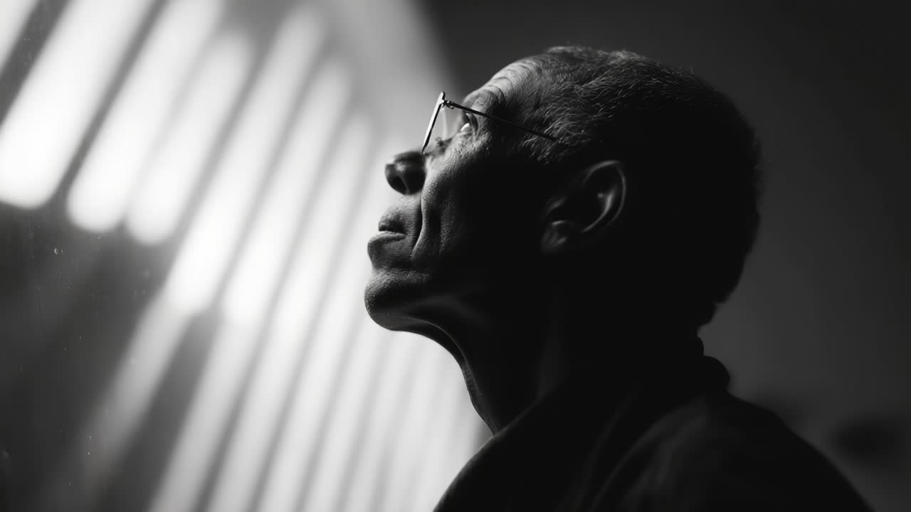 A Thoughtful Expression of Reflection and Contemplation Captured in Black and White Imagery, Showcasing an Individual Gazing Upon a Lighted Space