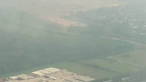 Plane flying over clouds and view of country