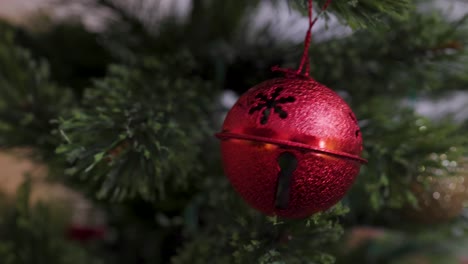 close-of-up-of-Christmas-ornaments-and-hands-reaching-out-to-view-them