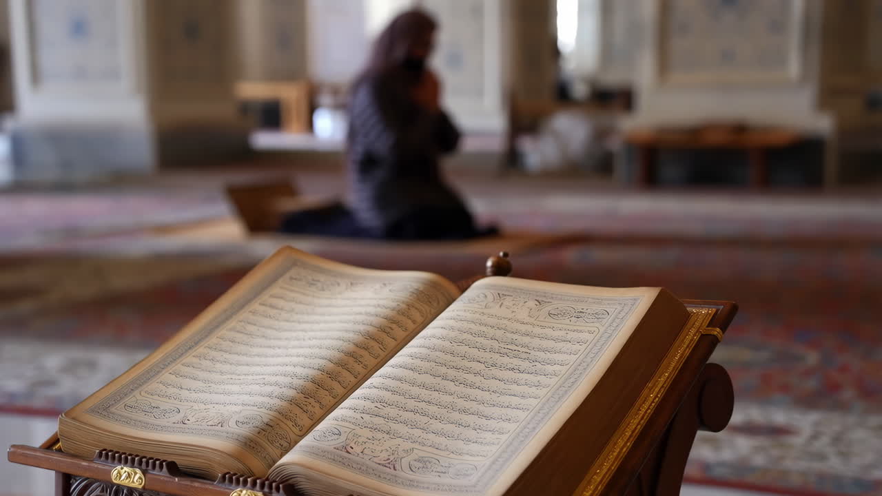 Un Corano aperto con una persona che prega sullo sfondo di una moschea