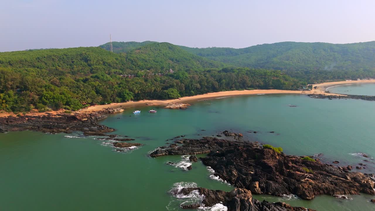 Panoramisk dronebilde av Om-stranden og mørke steiner i Karnataka, Sør-India.