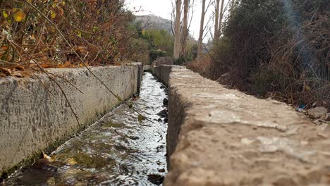 aqueduto com água doce que flui através do campo de agricultura rural jordaniana na jordânia, oriente médio