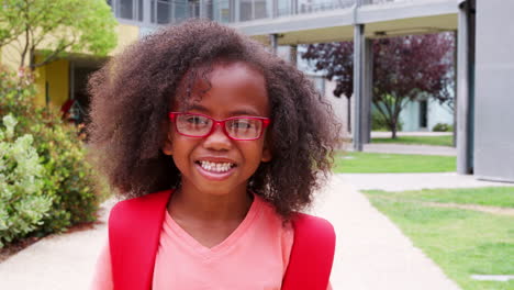 Una-Colegiala-De-Primaria-Con-Gafas-Mira-A-La-Cámara-Y-Sonríe