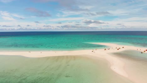 Touristen,-Die-Ihren-Erholsamen-Urlaub-An-Einem-Tropischen-Weißen-Sandstrand-Genießen,-Umgeben-Von-Türkisblauem-Pazifischem-Ozean-Und-Blauem-Himmel-Und-Wolken,-Drohnenantenne-4k