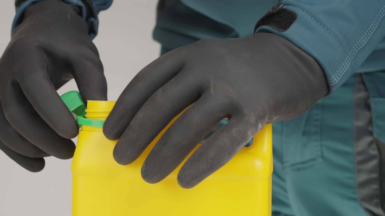 persona abriendo un recipiente de plástico amarillo con guantes