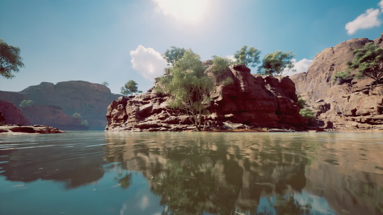 Natural rock formation and lush greenery reflected in calm water at midday