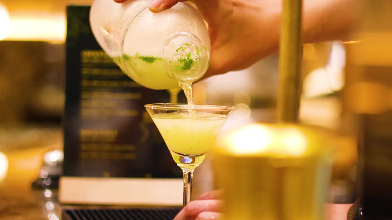 술집 주인이 유리잔에 테일을 능숙하게 부어 넣습니다.