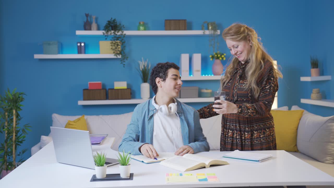 엄마는 집에서 공부하는 아들을 돌보고 있습니다.