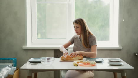mujer preparando un sándwich en una cocina