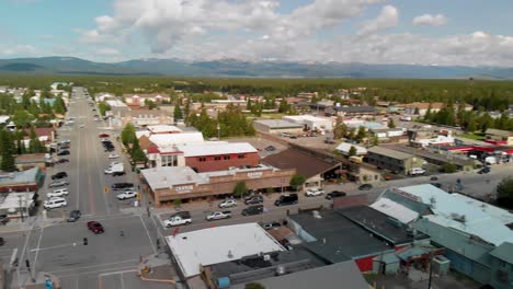 Pan-View-over-West-Yellowstone-City-Center-with-Avenue-and-Mountains-on-Horizon,-Montana,-USA