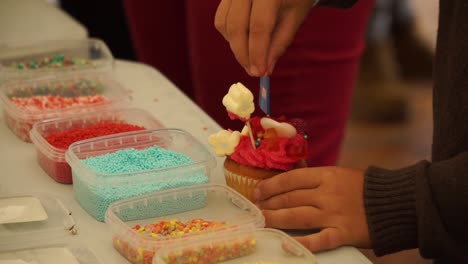 niño pequeño decorando cupcake