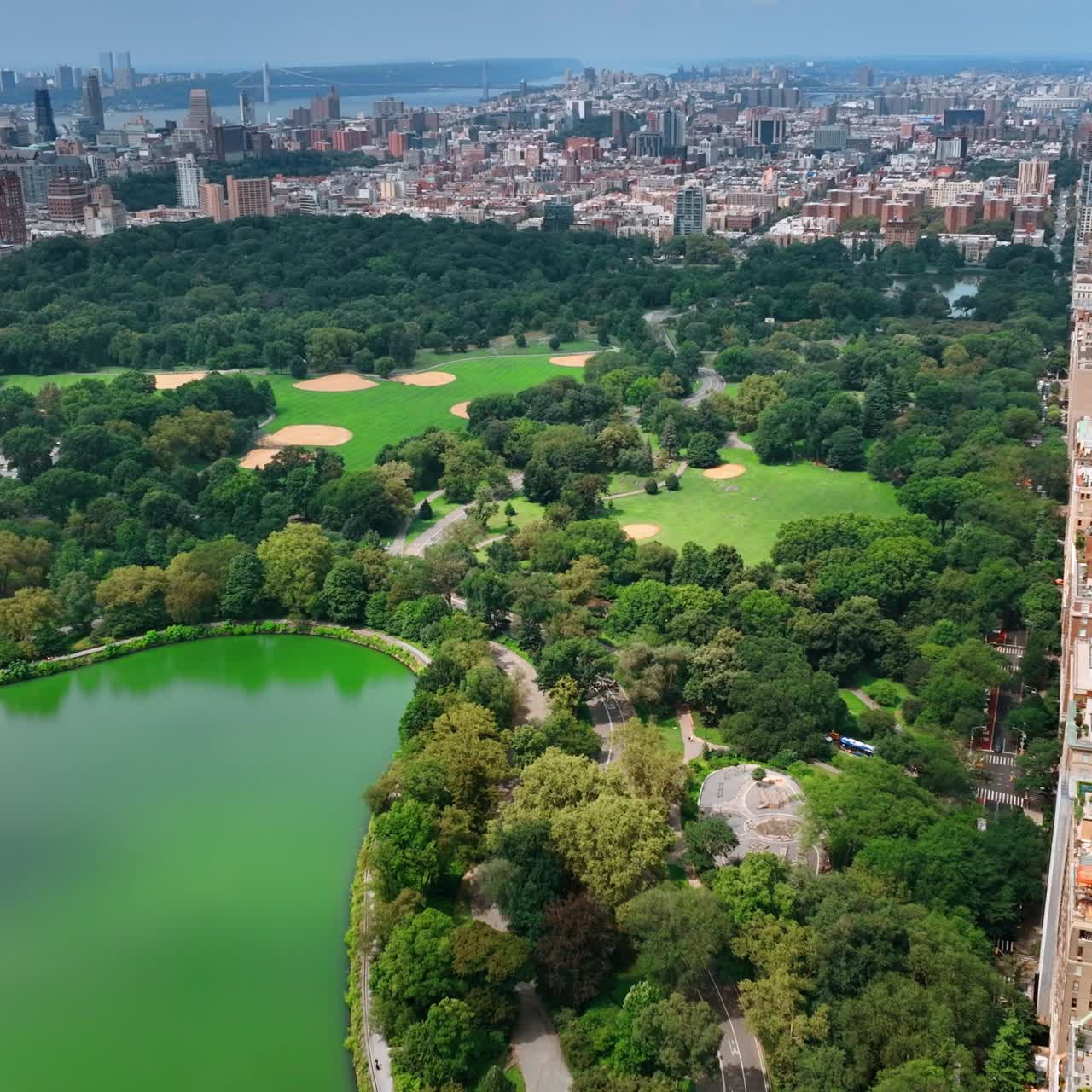 Marvelous scenery of Central Park with lake. Sunny cityscape of New York from aerial perspective