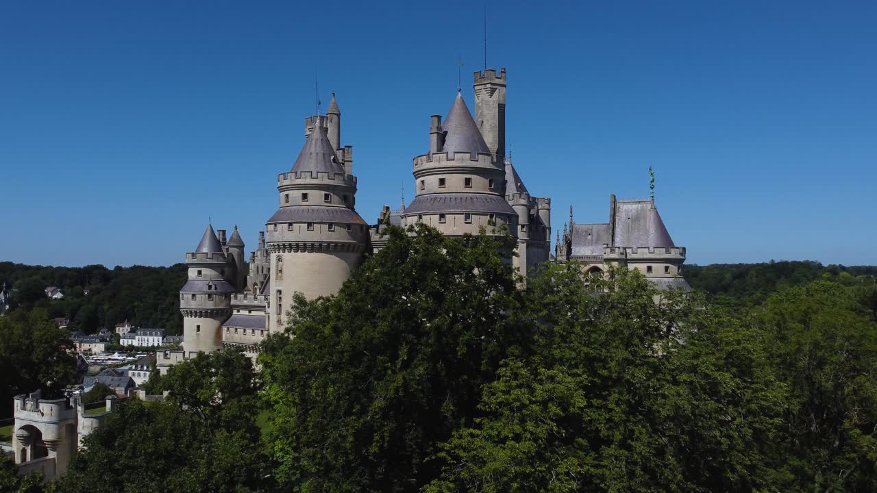 Revealing Pierrefonds castle, France over trees