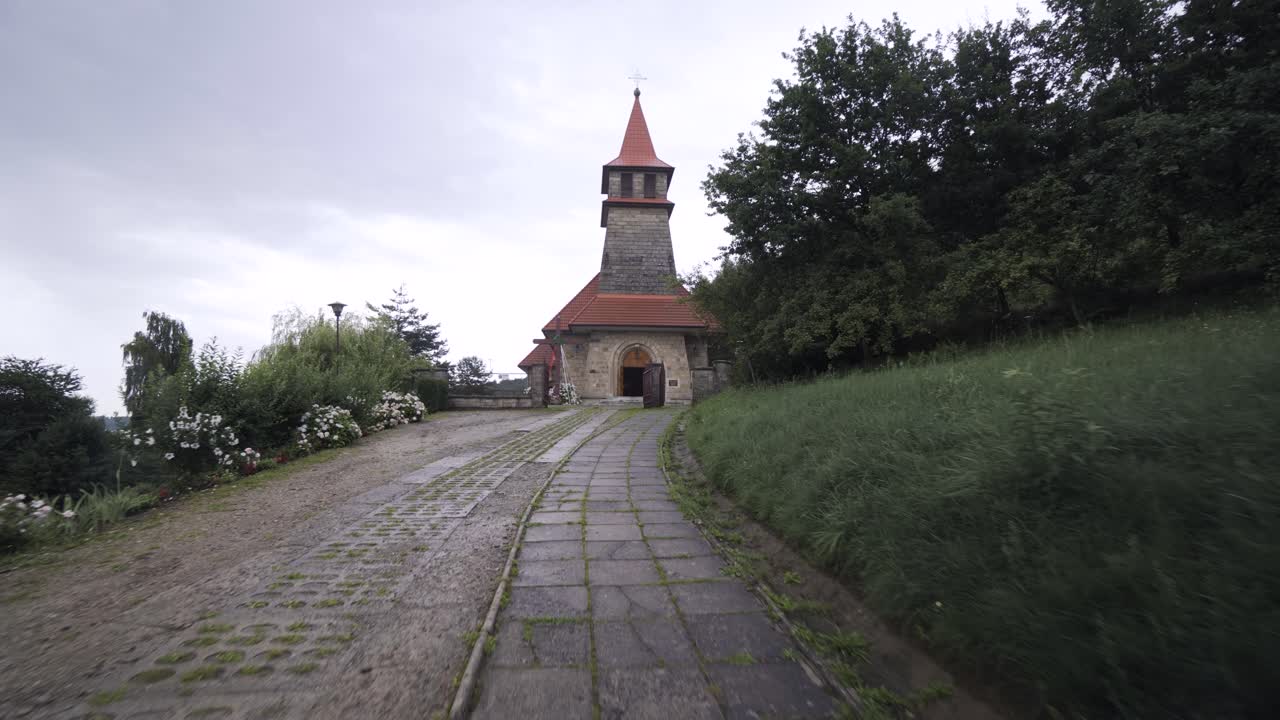 antigua iglesia gris ubicada en la cima de la colina en el bosque, día lluvioso