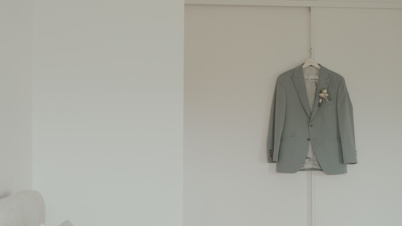 실내에 걸려 있는 부토니에가 달린 웨딩 수트 재킷