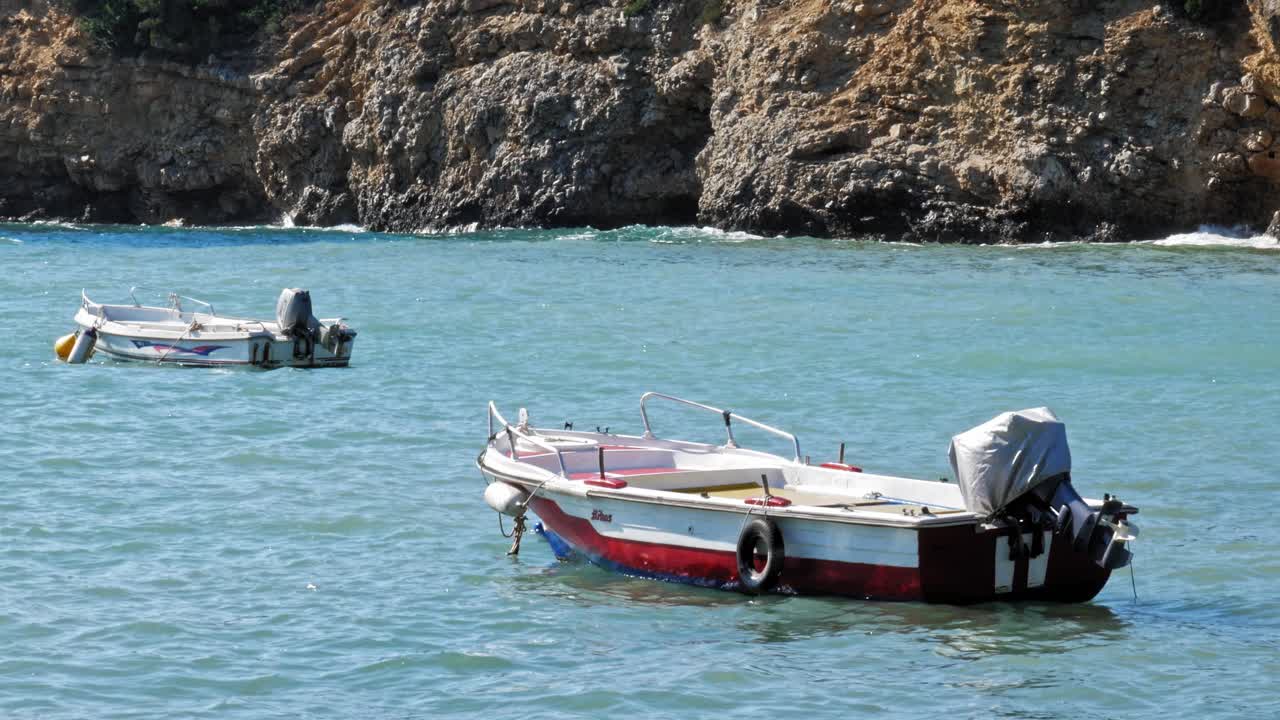 lanchas motoras ancladas en el océano en la playa de jerusalén en grecia - tiro estático