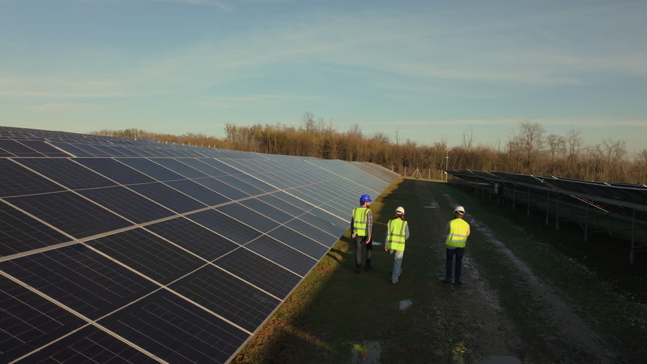 Workers Inspecting Solar Panels at a Solar Farm