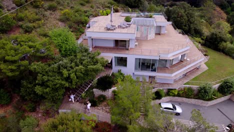 luxury real estate tour: aerial view of agent and clients entering magnificent two-storey villa on monaco's heights