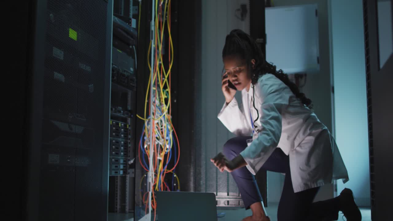 Animation of data processing over african american female engineer using laptop at server room