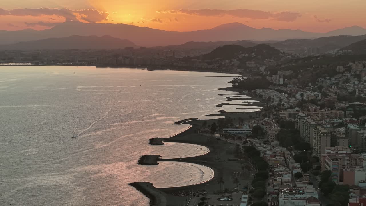 Vista aerea al tramonto su Malaga, Spagna, con cieli luminosi, spiagge sinuose e acque scintillanti del Mediterraneo, catturata da un drone per contenuti cinematografici di viaggio, paesaggi e aree urbane