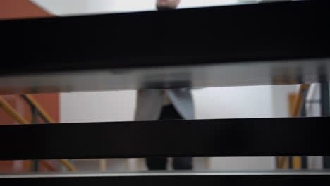 vista a través de las escaleras del hombre de negocios subiendo, cámara lenta