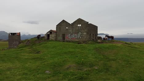 abandoned damaged old stone building in iceland, vandalized with graffiti, aerial view