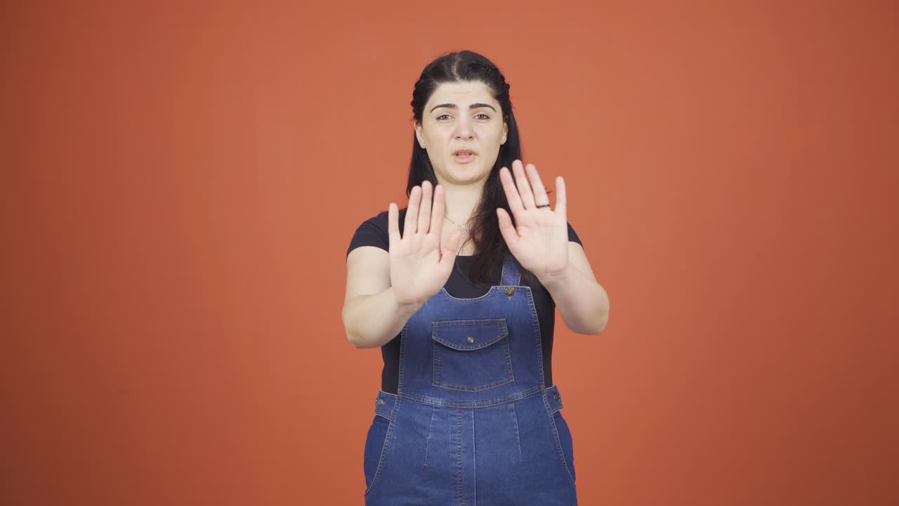 mujer haciendo una señal de alto para la cámara.