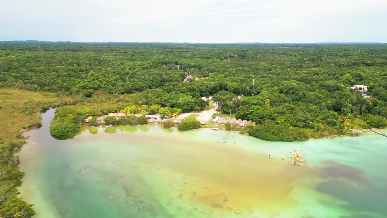 Thatched Roof Lodges And Lush Forest Trees In Bacalar Lagoon In Bacalar, Mexico, Yucatán Peninsula. Aerial Drone Shot