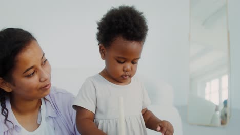 mother and toddler playing with building blocks