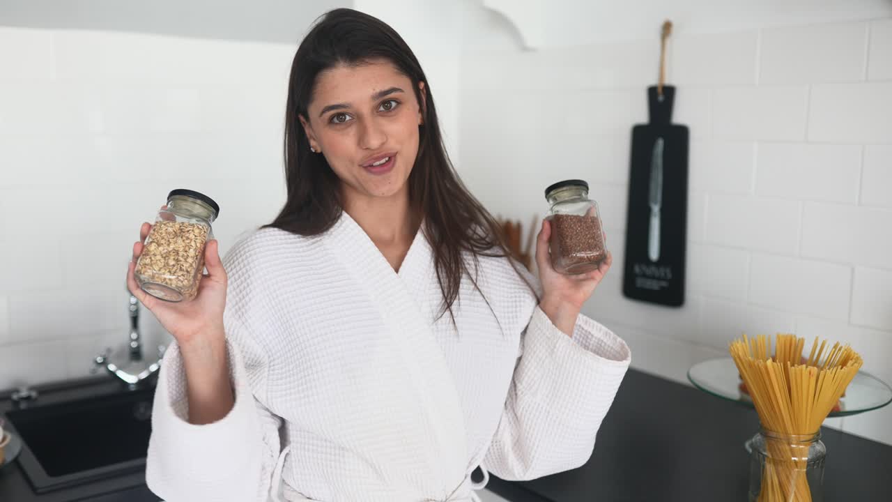 mujer comparando avena y trigo sarraceno en frascos en una cocina