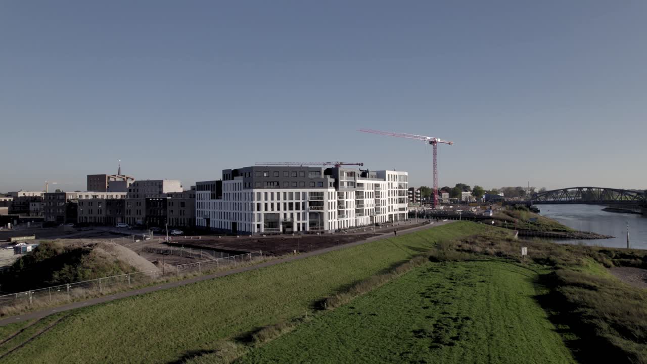 complejo de apartamentos kade noord en la orilla del río ijssel con grandes grúas rojas detrás en el barrio noorderhaven recientemente desarrollado en zutphen