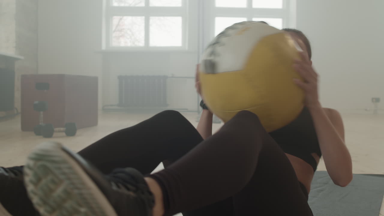 Fit Woman Doing Crunches With Heavy Ball