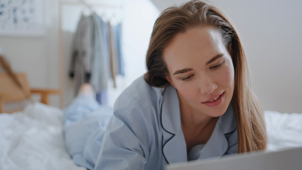 Serene girl reading book in cozy bedroom closeup. Calm woman posing at morning