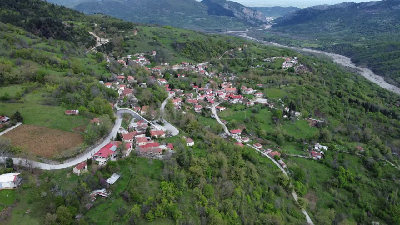 Dronekuva pienestä viehättävästä kylästä Kreikassa, piilossa laaksossa | 4K