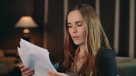 focused woman reading financial report in office. pensive businesswoman