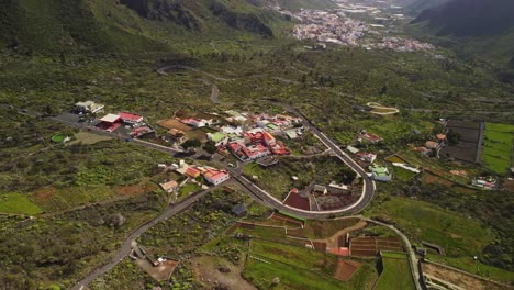 from above view at remote spanish village and winding road in the green valley