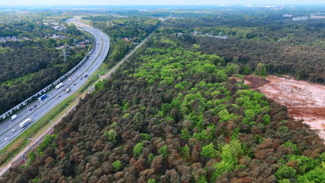 nature's contrast in dutch lands. green forests juxtaposed with cleared land near a highway showcase the contrasting landscapes of the netherlands