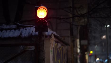Snowfalls-in-slow-motion-around-crossing-light-in-urban-city-with-graffiti