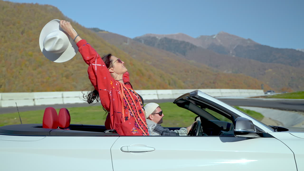 산 을 가로질러 컨버터블 로 경치 좋은 드라이브 를 즐기는 부부