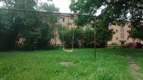 nostalgic children's swing on rusty frame in urban soviet era district