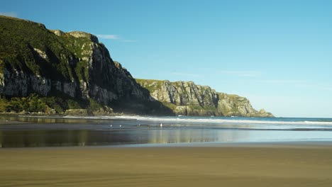 Zeitrafferaufnahme-Von-Wellen,-Die-Den-Sandstrand-In-Der-Purakaunui-Bay,-Catlins-Coast,-Neuseeland-Erreichen