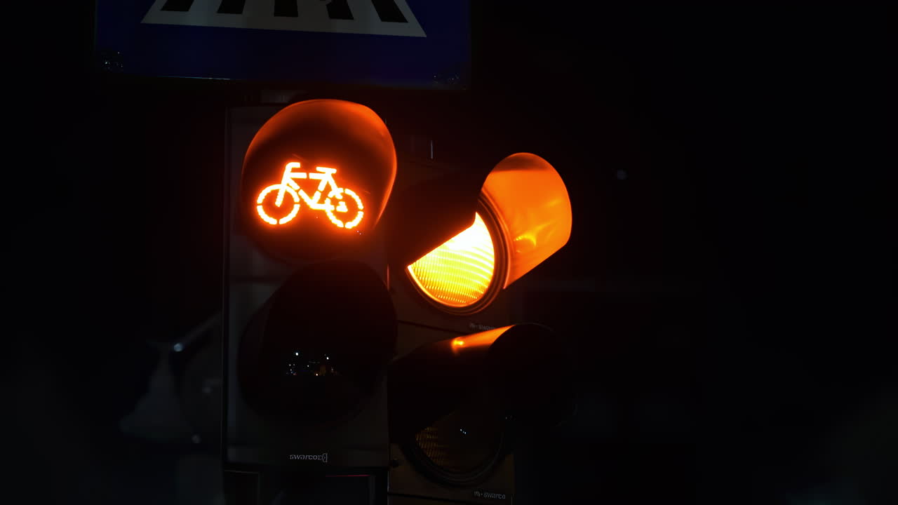 Two red traffic lights with bicycle logo on one at night in Bucharest, Romania